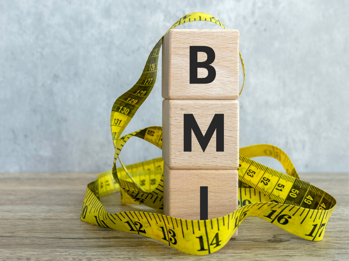 Wooden blocks spelling BMI surrounded by a yellow measuring tape, symbolizing body mass index and weight management awareness in Filipino health contexts.