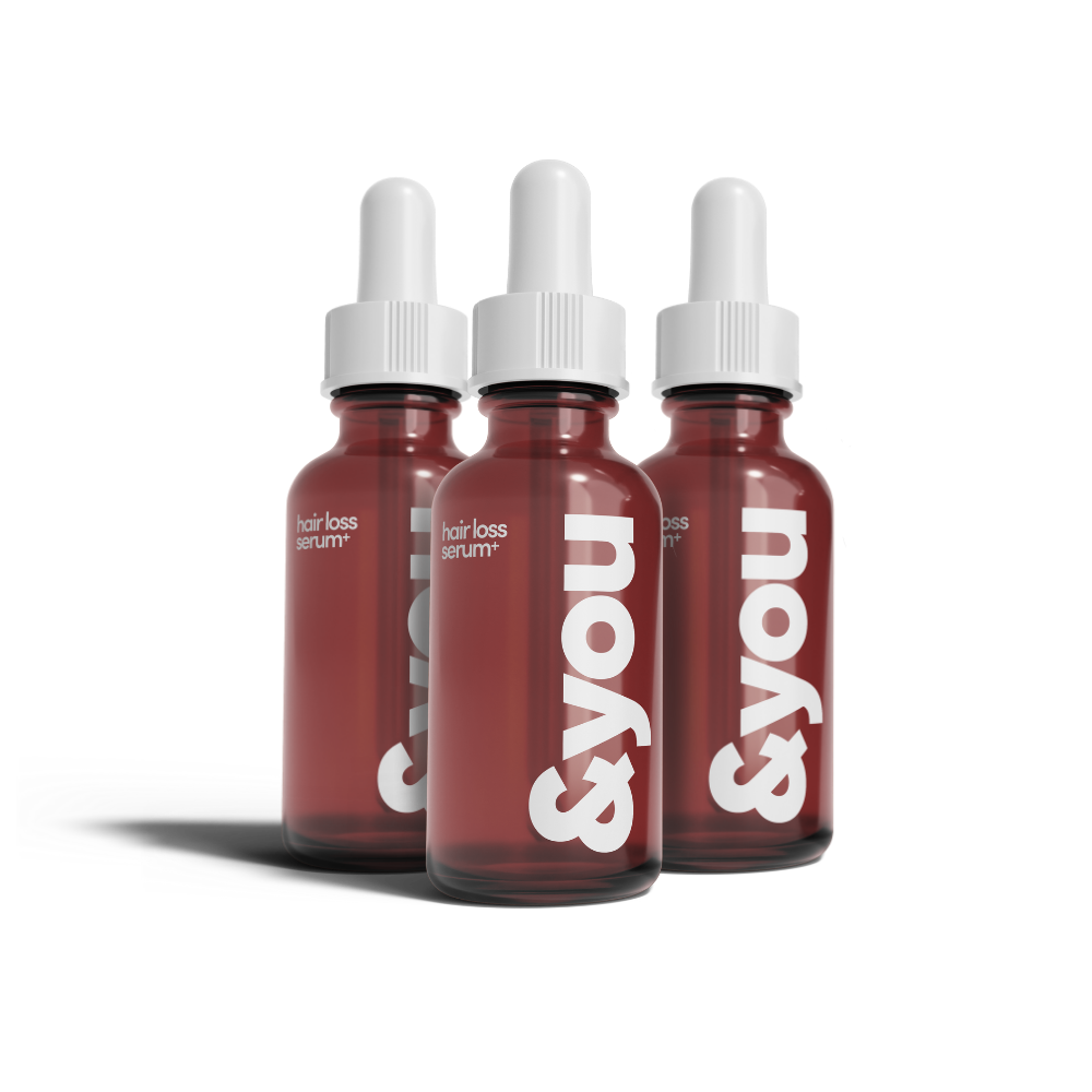 Brown glass bottle with a white dropper against a black background.